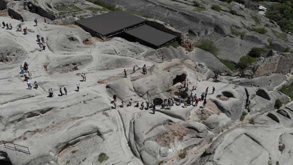 ტურისტები უფლისცეხის სამონასტრო კომპლექში