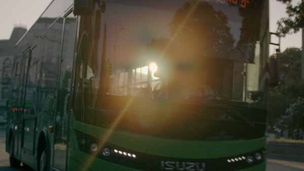 მწვანე ავტობუსი შემოდის გაჩერებაზე